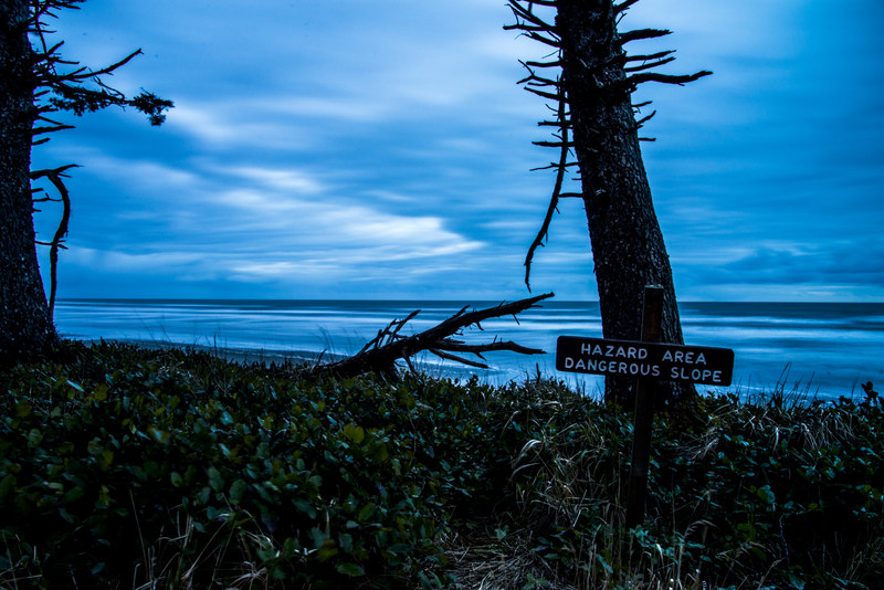 Hazard Area sign at Kalaloch Beach with long-exposure blue-hour ocean and dead trees silhouetted behind